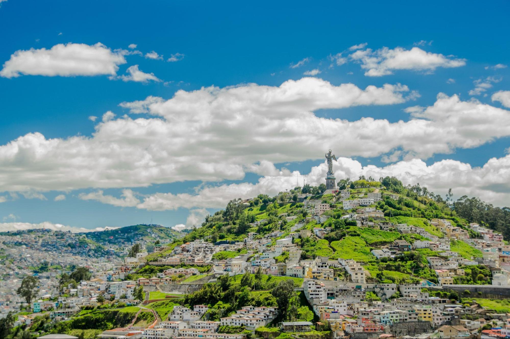 High view of the city of Quito and some buildings, with Panecillo hill in the top of the mountain
